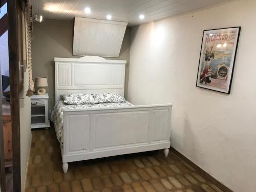 um quarto com uma cama branca num quarto em Gîte en pierre au cœur des chiens de traîneau em Mirmande