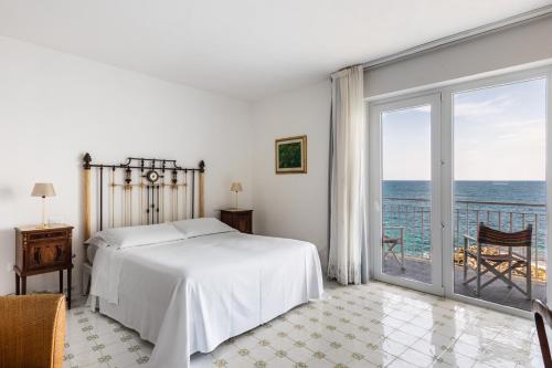 a bedroom with a bed and a view of the ocean at Giuggiulena in Siracusa