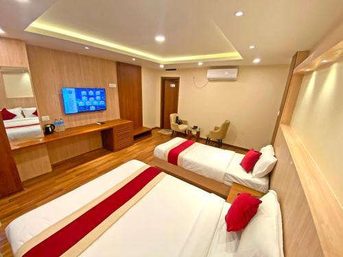 Hotel Nilakantha Pvt. Ltd في كاتماندو: غرفة فندقية بسريرين وتلفزيون بشاشة مسطحة