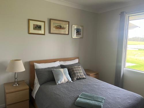 a bedroom with a bed with pillows and a window at Freyjas Guest Suite in Curra