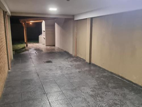 an empty room with a tile floor and a hallway at Complejo Boulevard Plottier in Plottier