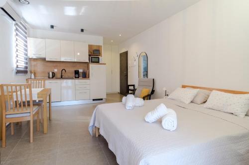 sypialnia z 2 łóżkami i stołem oraz kuchnia w obiekcie Apartments Grape w mieście Pirovac