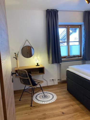 a bedroom with a desk and a chair and a bed at Ferienwohnung Einklang in Krün