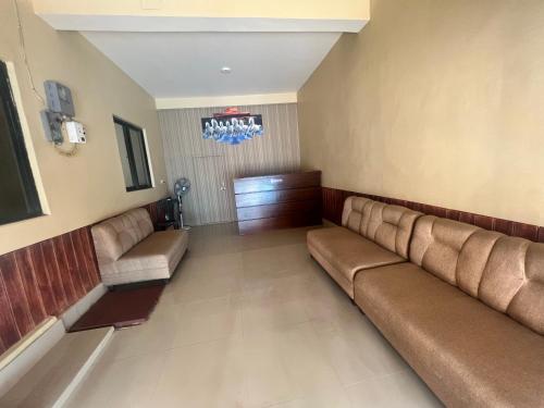 a waiting room with brown leather couches in a building at Hotel Down To Earth in Kathmandu