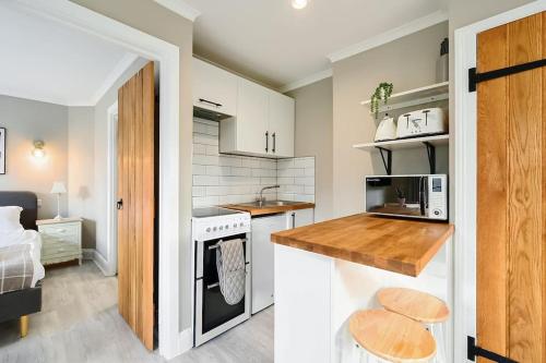 a small kitchen with a sink and a stove at Garden Flat, Walnut Tree House in Rustington