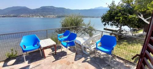 a balcony with chairs and a table and a view of the water at Apartmani Miholjska prevlaka in Tivat