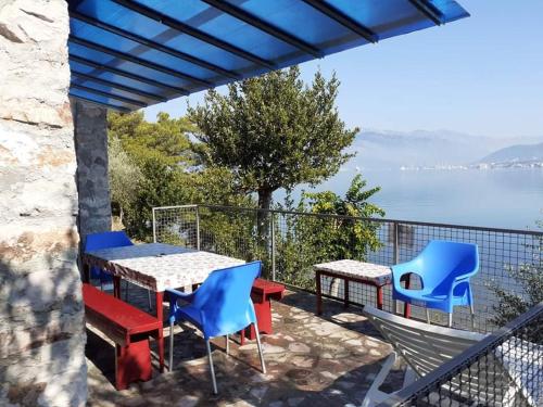 a patio with tables and chairs and a view of the water at Apartmani Miholjska prevlaka in Tivat