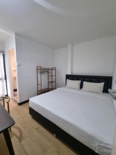 een slaapkamer met een groot wit bed in een kamer bij Owl's Nest suk 30 in Bangkok