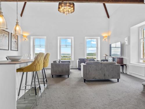 uma sala de estar com paredes e janelas brancas em Pass the Keys Yew Tree Stunning Apartment with Sea View em Grange Over Sands