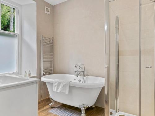 uma casa de banho branca com uma banheira e um chuveiro em Pass the Keys Yew Tree Stunning Apartment with Sea View em Grange Over Sands