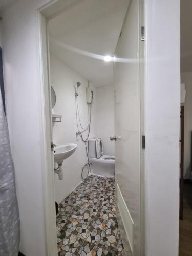 een badkamer met een douche, een wastafel en een toilet bij Owl's Nest suk 30 in Bangkok