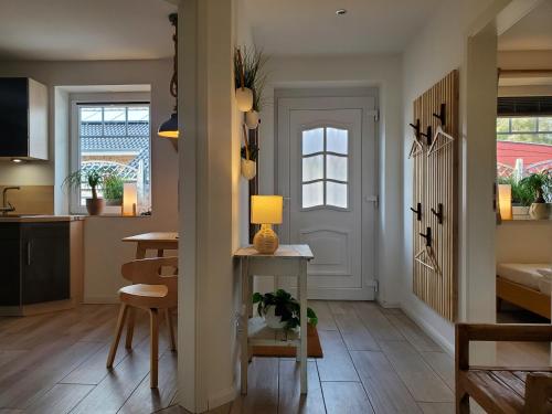 een keuken en een woonkamer met een tafel en een deur bij NordseeLiebe - Zeit Für Meer in Bredstedt