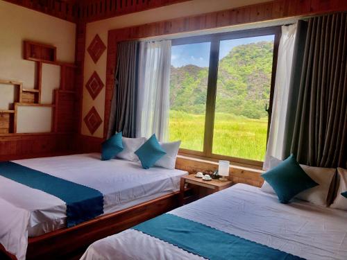 a bedroom with two beds and a window with a view at Rosa Garden in Ninh Binh