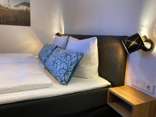 a couch with a blue and white pillow and a lamp at Ferienwohnung Einklang in Krün