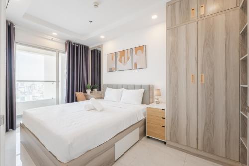 una camera con un grande letto e un armadio in legno di Big Promo 20% Luxury 2BR Apt - City Skyline View ad Ho Chi Minh