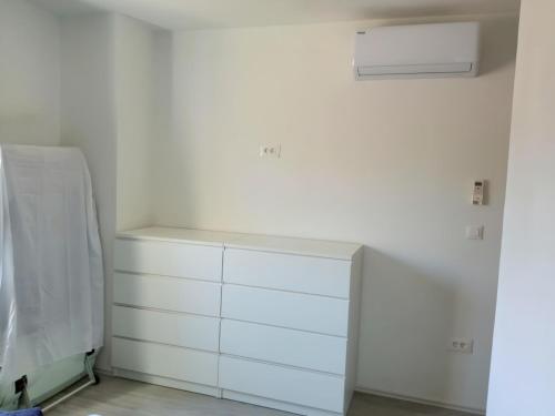 a kitchen with white cabinets and a white wall at Apartment Valentino in Vabriga