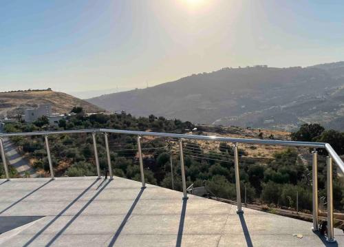 a balcony with a view of a mountain at Farmhouse with Pool and Breathtaking Views in Amman