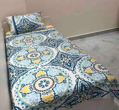 a bed with a blue and yellow blanket and pillows at Farmhouse with Pool and Breathtaking Views in Amman