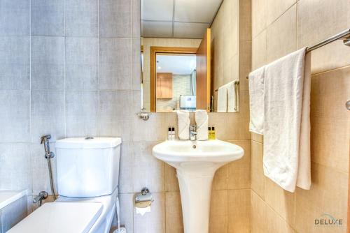 La salle de bains est pourvue d'un lavabo, de toilettes et d'un miroir. dans l'établissement Elegant Studio at DAMAC Lincoln Park A Arjan-Dubailand by Deluxe Holiday Homes, à Dubaï