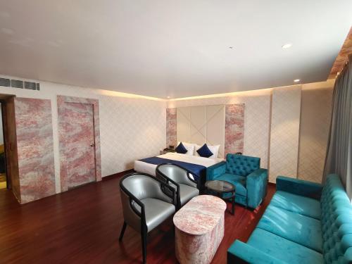 a hotel room with a bed and a couch at The Emerald Hotel & Siya Milan Banquets in Muzaffarpur