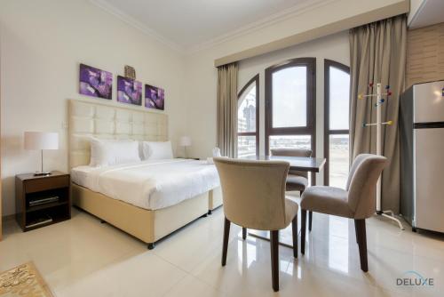 - une chambre avec un lit, une table et des chaises dans l'établissement Elegant Studio at DAMAC Lincoln Park A Arjan-Dubailand by Deluxe Holiday Homes, à Dubaï