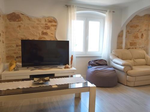 a living room with a flat screen tv and a couch at Apartment Valentino in Vabriga