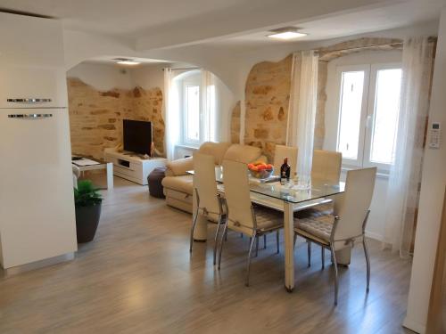 uma sala de jantar e sala de estar com mesa e cadeiras em Apartment Valentino em Vabriga