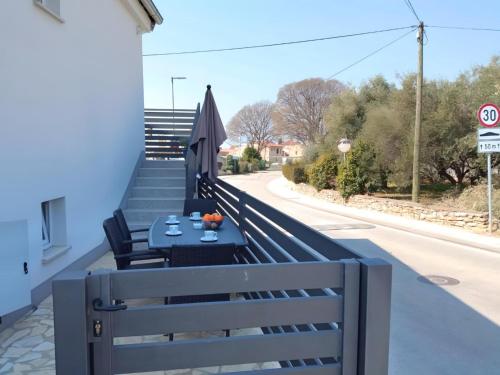 a table on the side of a balcony with an umbrella at Apartment Valentino in Vabriga