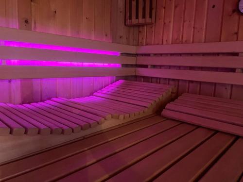 two beds in a room with pink lights at Kota Wadway in Spanbroek