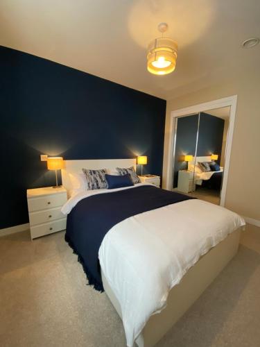 1 dormitorio con 1 cama grande y pared azul en NEW pet friendly holiday home, sleeps 6, Stromness, en Stromness