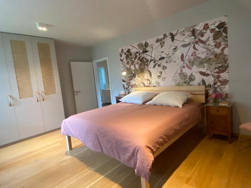 a bedroom with a bed with a floral wall at copper beech place in Achim