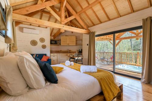 Cette chambre comprend un grand lit et un plafond en bois. dans l'établissement Les Cabanes Suspendues, à Satillieu