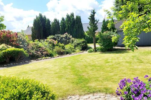 a garden with green grass and purple flowers at Thuya Rica house (1.6km to Legoland) in Billund