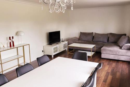 a living room with a couch and a table and chairs at Thuya Rica house (1.6km to Legoland) in Billund