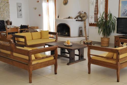 a living room with wooden furniture and a fireplace at Eri Hotel in Parikia