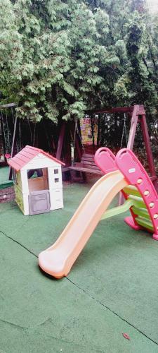 un parque infantil con tobogán y una casa de juegos en Zajazd na Liwskich Mostach, en Węgrów