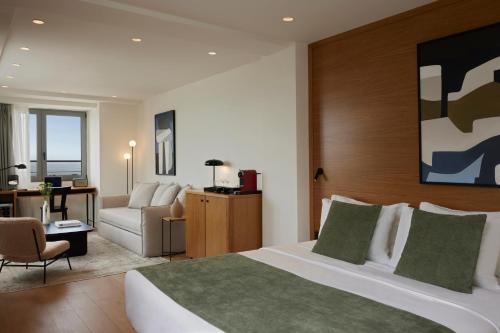 a hotel room with a large bed and a couch at Noa Hotel in Thessaloniki
