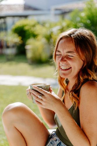 a woman laughing while looking at her cell phone at Oustau Camarguen Hôtel & Spa in Le Grau-du-Roi