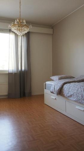 1 dormitorio con cama y lámpara de araña en Lumi Room en Rovaniemi
