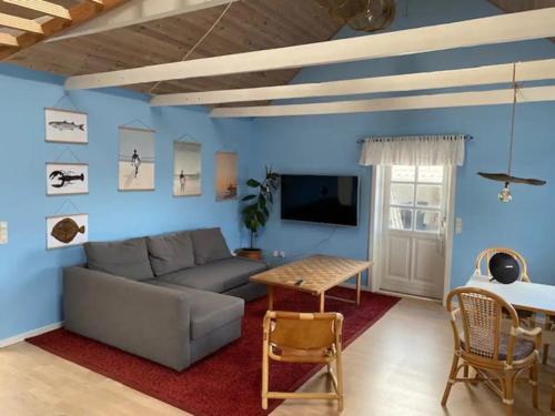Agger Beach Apartment في Vestervig: غرفة معيشة مع أريكة وطاولة