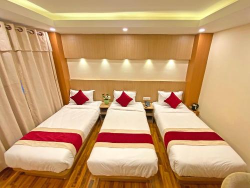 two beds in a hotel room with red pillows at Hotel Nilakantha Pvt. Ltd in Kathmandu