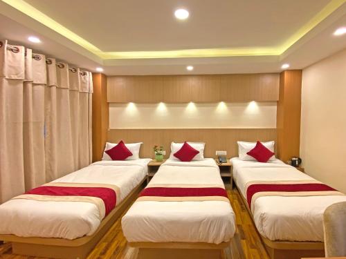 a row of three beds in a room at Hotel Nilakantha Pvt. Ltd in Kathmandu