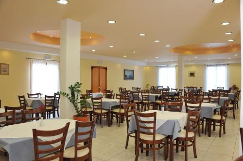 a dining room with white tables and chairs at Eri Hotel in Parikia