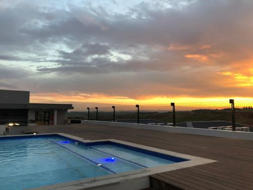ein Pool auf dem Dach eines Gebäudes mit Sonnenuntergang in der Unterkunft Zimbali Lakes Boulevard Suite 257 in Ballito