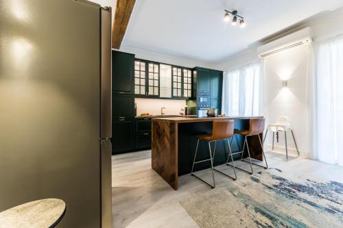 a kitchen with green cabinets and a large refrigerator at BALEA Suite apartment in San Sebastián