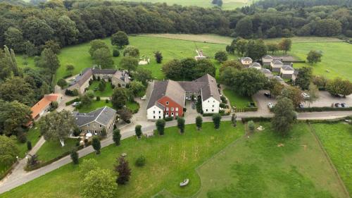 an aerial view of a large house in a green field at Bungalowpark Landsrade in Gulpen