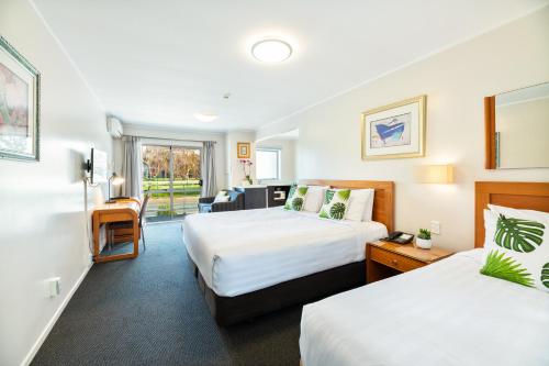 a hotel room with two beds and a desk at Best Western Newmarket Inn & Suites in Auckland
