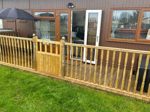 a wooden fence in front of a house at S and S Chalets Mablethorpe in Mablethorpe