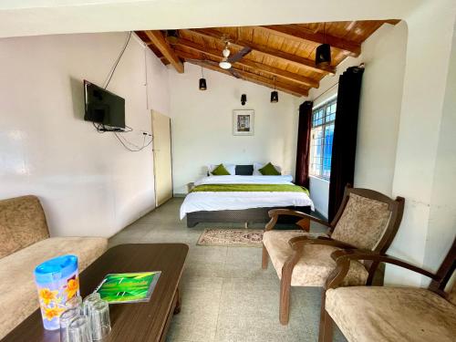 a bedroom with a bed and a table and chairs at CENTRAL HOTEL by RB group Mall Road-prime-location in-front-of-naini-lake hygiene-and-spacious-room in Nainital