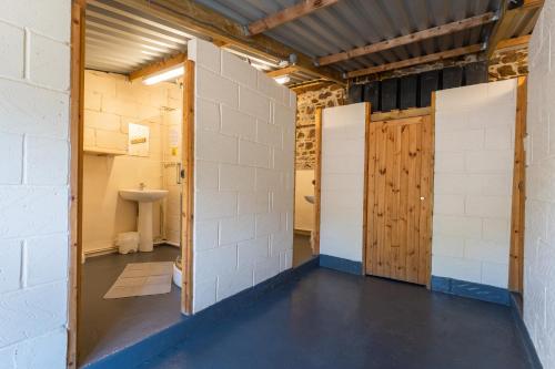 een badkamer met 2 deuren en een wastafel in een kamer bij Dartmoor Lodge (Oak Tree Lane) in Okehampton